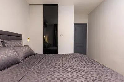 a bedroom with a large bed and a black door at Happy People Plovdiv - Grey 1-BD Apartment by Flat Mаnager in Plovdiv