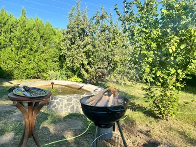 a bbq and a grill in a yard at Cozy Quiet Retreat 70km from Sofia in Kyustendil
