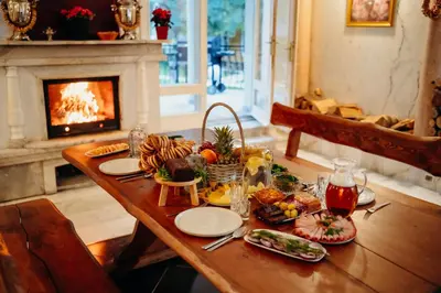 a table with food and a fireplace in a living room at Вила Княжеска баня in Sofia