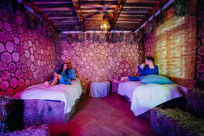 two people sitting on beds in a room with pink walls at Вила Княжеска баня in Sofia