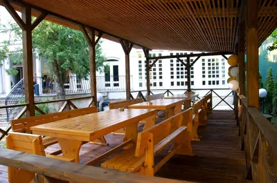 a row of wooden tables and benches in a pavilion at Вила Княжеска баня in Sofia