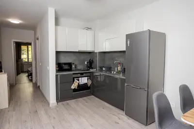 a kitchen with stainless steel appliances and white cabinets at Cozy 1BR in Heart of Oborishte with Private Parking in Sofia