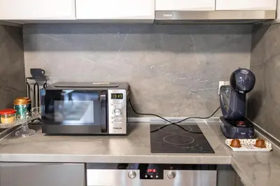 a microwave oven sitting on a counter in a kitchen at Cozy 1BR in Heart of Oborishte with Private Parking in Sofia