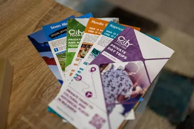 a bunch of brochures sitting on a table at Cozy 1BR in Heart of Oborishte with Private Parking in Sofia