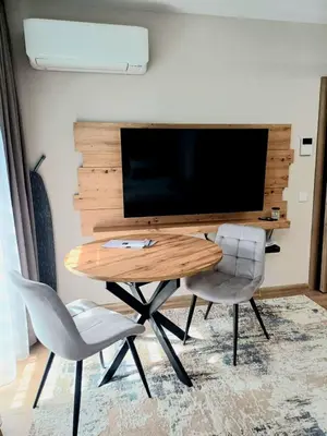 a table and two chairs in a room with a tv at Apartmenthaus Oborishte - 27 in Panagyurishte