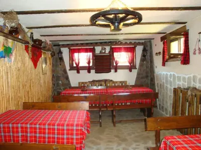 a dining room with two tables and red clothed tables at Дамянова Къща in Dobrinishte