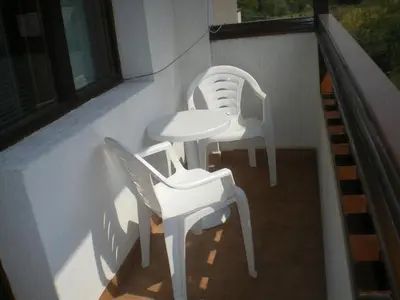 two white chairs and a table on a balcony at Дамянова Къща in Dobrinishte