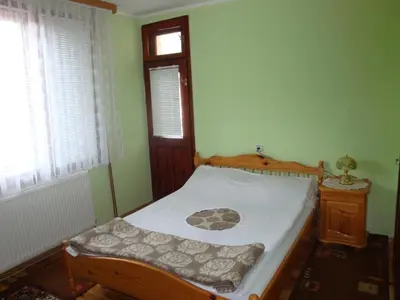 a bedroom with a bed and a window at Дамянова Къща in Dobrinishte