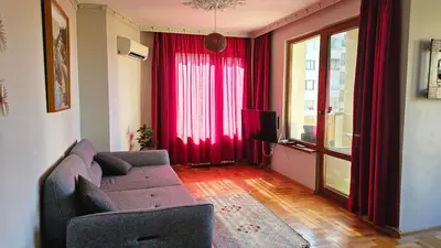 a living room with red curtains and a couch at Business Park Retreat: 1BR with Mountain View in Sofia