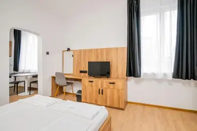 a hotel room with a bed and a desk with a television at Cozy Flats Near Alexander Nevski Cathedral by Flat Mаnager in Sofia
