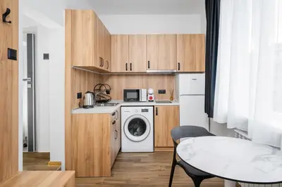 a small kitchen with a washing machine and a table at Cozy Flats Near Alexander Nevski Cathedral by Flat Mаnager in Sofia