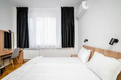 a bedroom with a bed and a desk and a window at Cozy Flats Near Alexander Nevski Cathedral by Flat Mаnager in Sofia