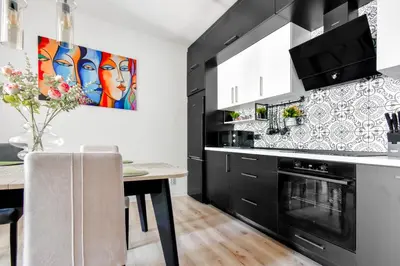 a kitchen with black cabinets and a dining room table at Prime Spot for 5 Full Kitchen Wi-Fi AC in Sofia