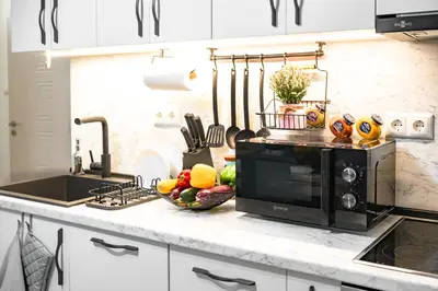 a kitchen counter with a microwave and a bowl of fruit at 2BR Downtown Suit Next to Nevski Cathedral - AC in Sofia