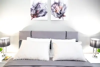 a bedroom with a bed with two paintings on the wall at 2BR Downtown Suit Next to Nevski Cathedral - AC in Sofia