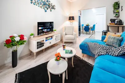 a living room with a blue couch and a tv at 2BR Downtown Suit Next to Nevski Cathedral - AC in Sofia