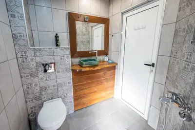 a bathroom with a toilet and a sink and a mirror at Къща за гости Приказка in Klisura
