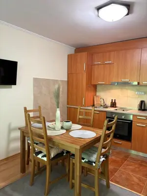 a kitchen with a wooden table and chairs at Николай Желев-Първи ЕООД in Pamporovo