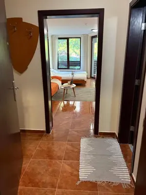 a hallway with a room with a couch and a table at Николай Желев-Първи ЕООД in Pamporovo