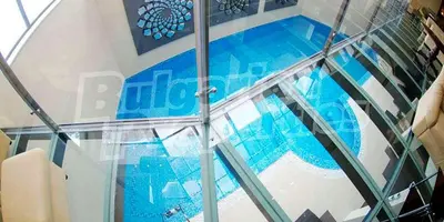 a glass floor in a building with a swimming pool at Студио в Хотел Айсберг in Borovets