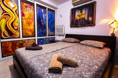 a bedroom with a bed with paintings on the wall at Residence Art Guest House in Plovdiv