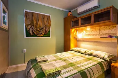 a bedroom with a bed with a plaid blanket at Residence Art Guest House in Plovdiv
