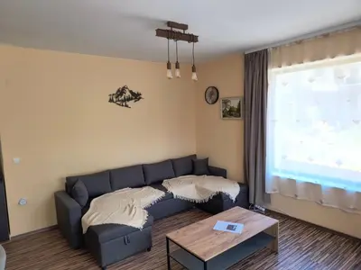 a living room with a blue couch and a table at Апартамент за гости Александър in Chepelare