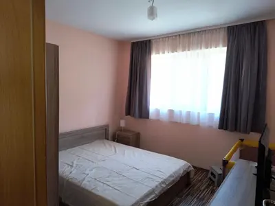 a small bedroom with a bed and a window at Апартамент за гости Александър in Chepelare