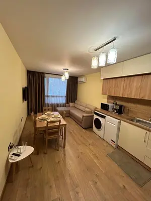 a kitchen and living room with a table and a couch at New & Stylish Apartment Axel with Mountain Views in Smolyan