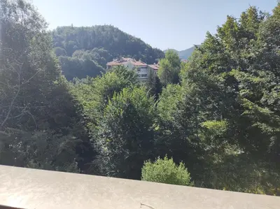 a house in the middle of a forest of trees at New & Stylish Apartment Axel with Mountain Views in Smolyan