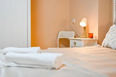 a bedroom with two beds and a lamp on a table at Central 47 in Sofia