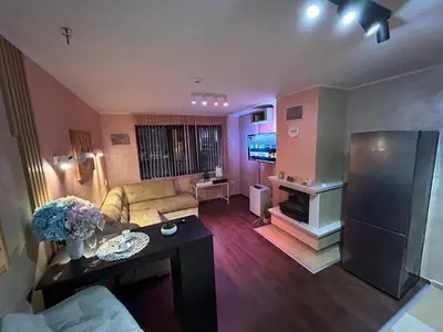 a living room with a couch and a tv at 2-bedroom, 2-bathroom with fireplace and garden at Winslow Infinity in Bansko