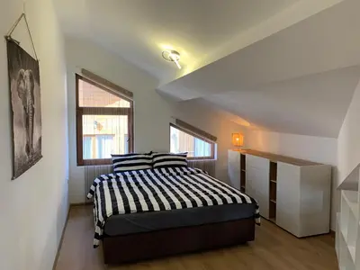 a bedroom with a bed with a black and white comforter at Mountain View in Razlog
