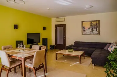 a living room with a table and a couch at Апартамент Пирин Apartment Pirin in Sandanski
