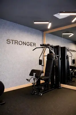 a gym with a chair and a wall with the word stronger at B1 Downtown Hotel, Sofia in Sofia