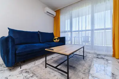 a living room with a blue couch and a table at Lauta Forest 1-bedroom apartment in Plovdiv