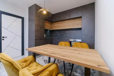 a dining room with a wooden table and yellow chairs at Lauta Forest 1-bedroom apartment in Plovdiv