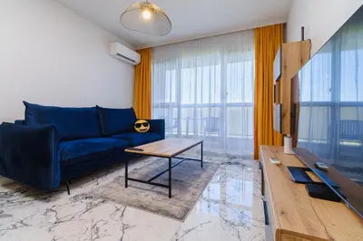 a living room with a blue couch and a table at Lauta Forest 1-bedroom apartment in Plovdiv