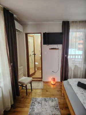a bedroom with a bed and a chair and a mirror at Къща за гости ФЪН ШУЙ 88 in Dobrinishte