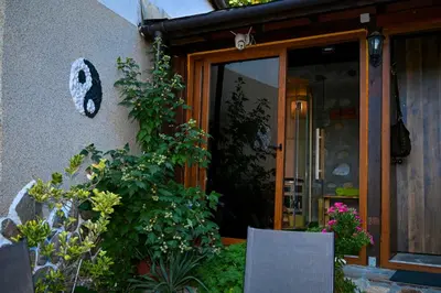 a front door of a house with plants and flowers at Къща за гости ФЪН ШУЙ 88 in Dobrinishte
