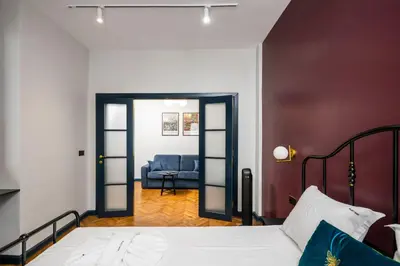 a bedroom with a bed and a blue chair at Royal Retreat - Your central designer spot by Flat Mаnager in Sofia