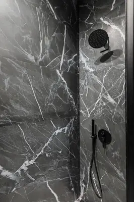 a shower with a black and white marble wall at Royal Retreat - Your central designer spot by Flat Mаnager in Sofia