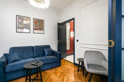 a living room with a blue couch and a chair at Royal Retreat - Your central designer spot by Flat Mаnager in Sofia
