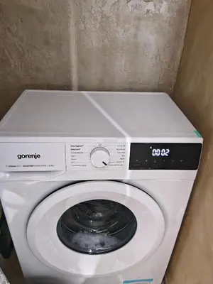 a white washing machine in a corner of a room at Apartment 59 in Sofia