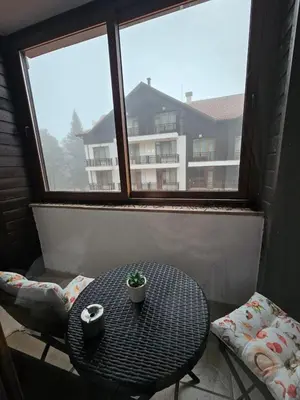 a table and chairs in a room with a window at Cozy Studio in Semiramida Gardens - Borovets Hills 39 in Borovets