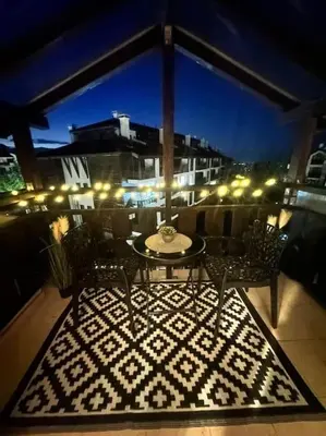 a patio with a table and chairs on a balcony at Pirin Sky in Bansko