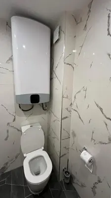 a bathroom with a toilet with a paper dispenser on the wall at Paradise Park Apartment Central Sofia Gem in Sofia