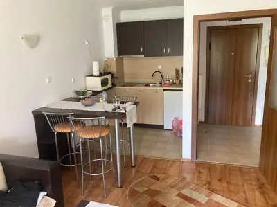 a kitchen with a table and stools in a room at Ruhig in den Bergen Bulgariens in Bansko