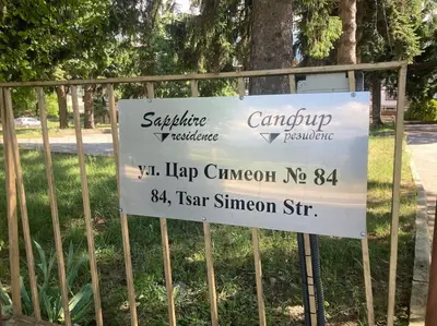 a sign on a fence in front of a park at Ruhig in den Bergen Bulgariens in Bansko
