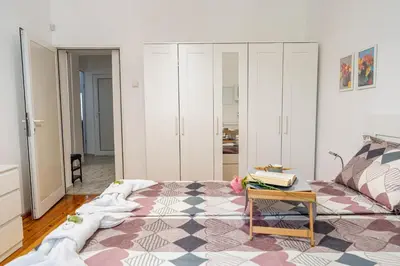 a room with a bed and a table and cabinets at The Red Sofa City Retreat in Sofia